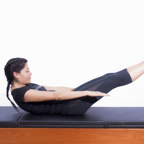 Mujer realizando ejercicio de pilates The hundred