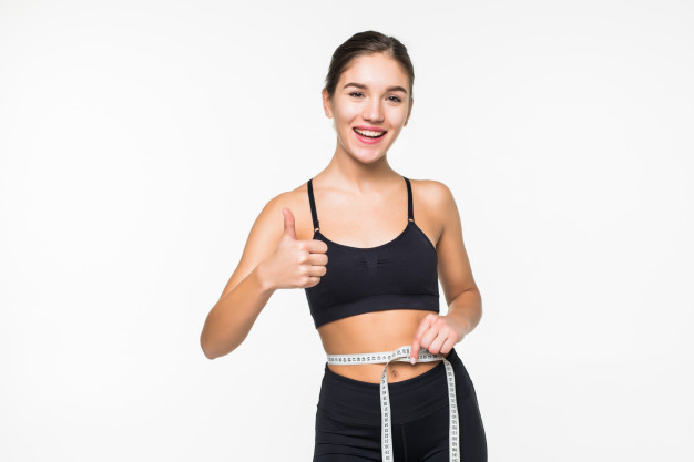 Mujer que se mide con huincha para adelgazar con pilates