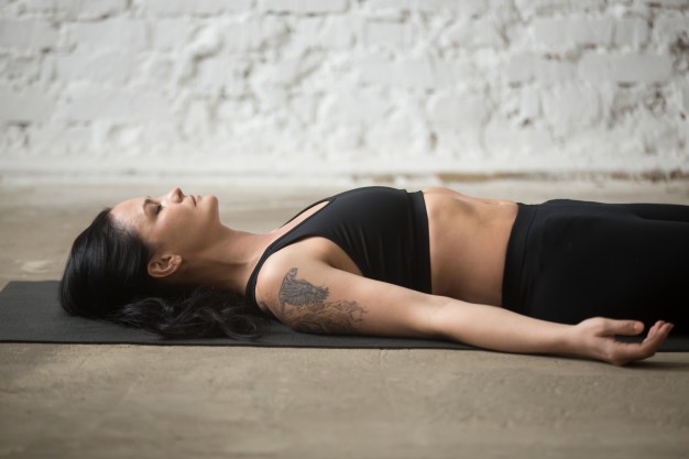 Mujer acostada entrenando patrones de respiración en pilates