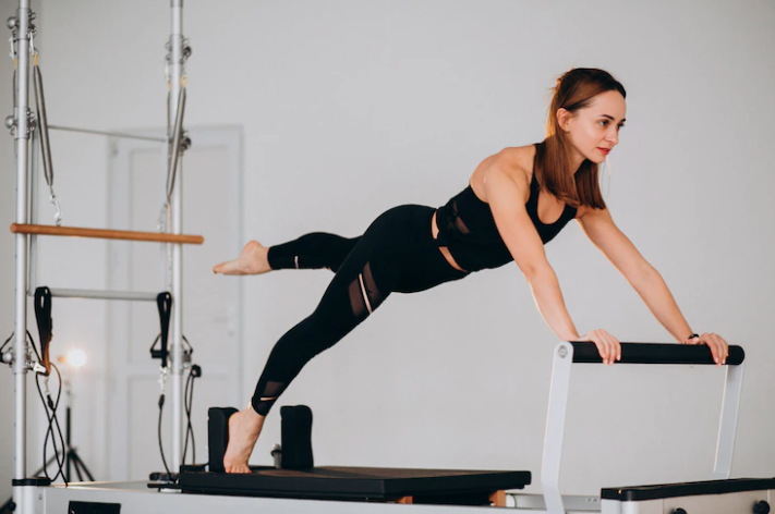 Mujer en el reformador de Pilates